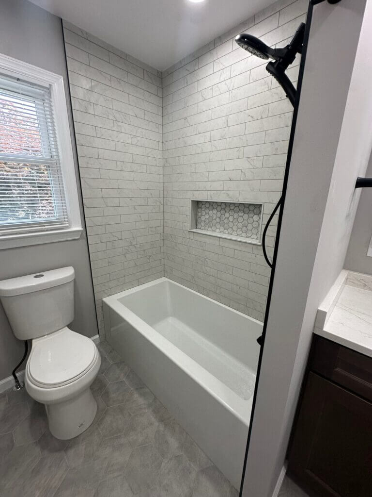 Family bathroom with a subway-tile tub surround and a modern handheld shower