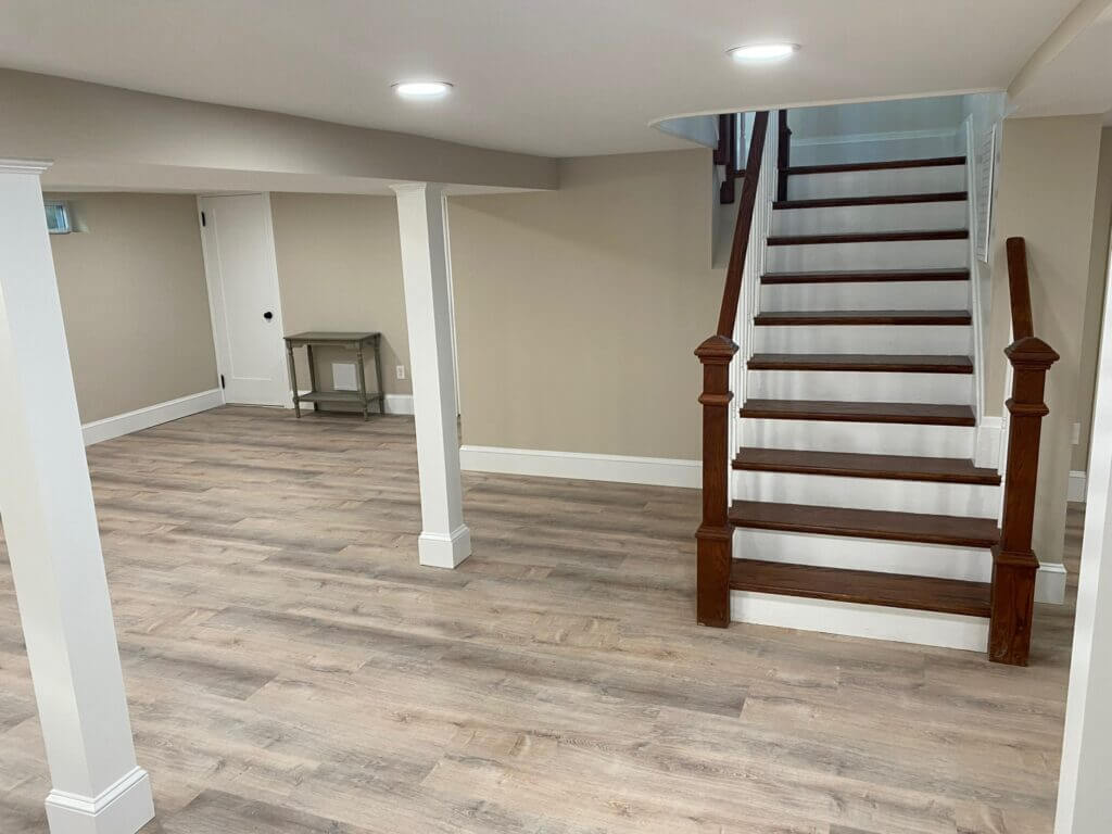 Finished basement family room with an oak staircase and finished support column