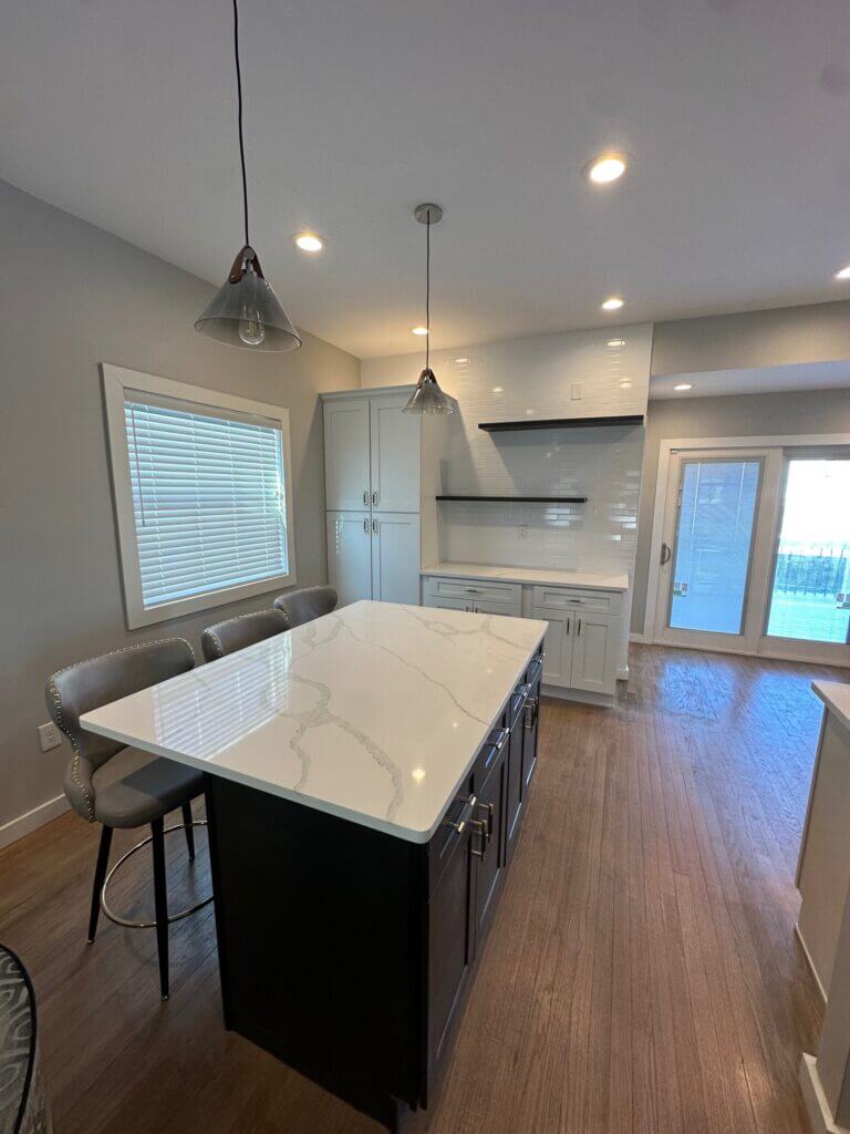 Open kitchen remodel with a quartz island, counter seating and recessed lighting