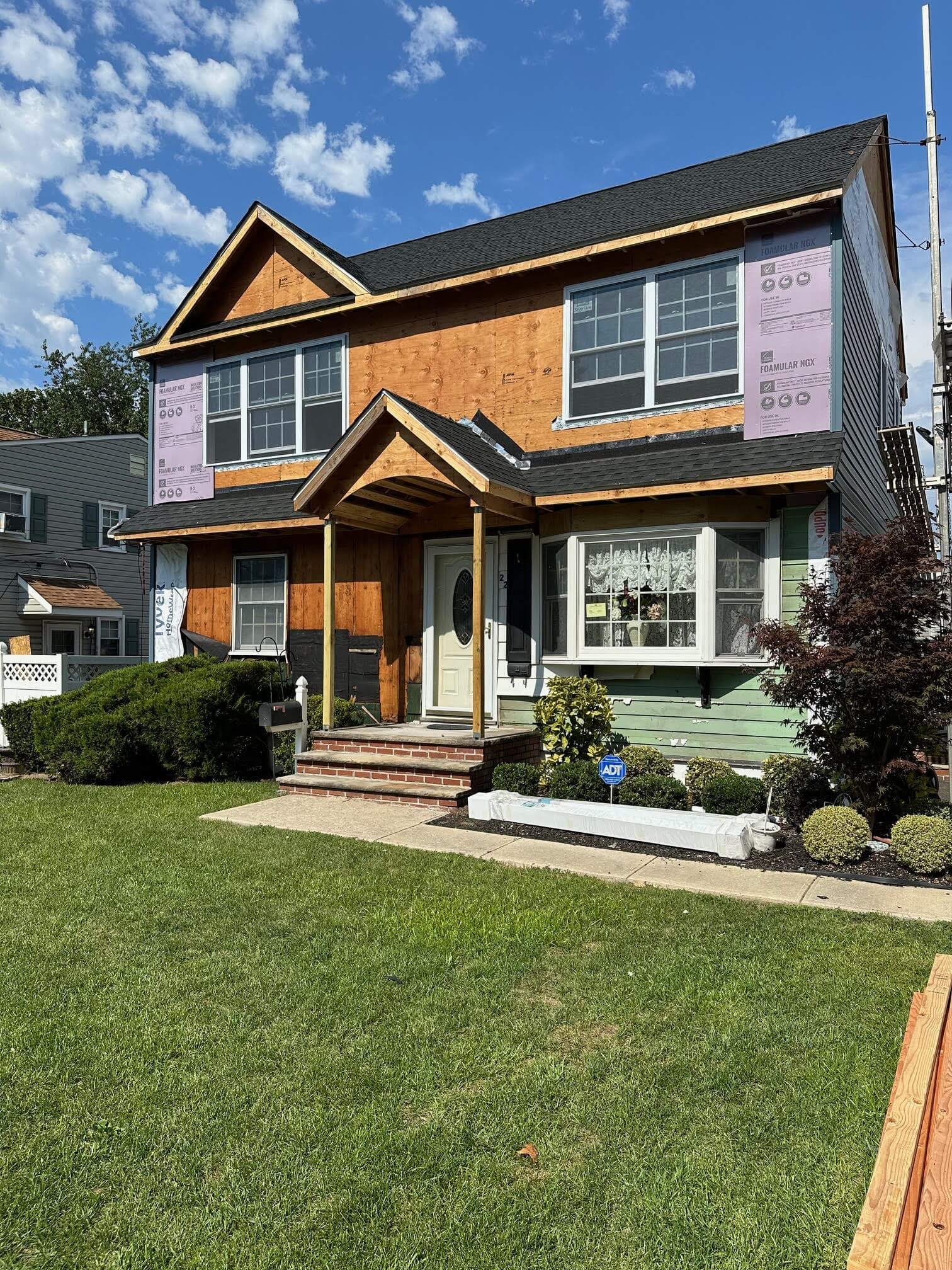 Before and during second story addition showing new wood framing and house wrap on Edison NJ home
