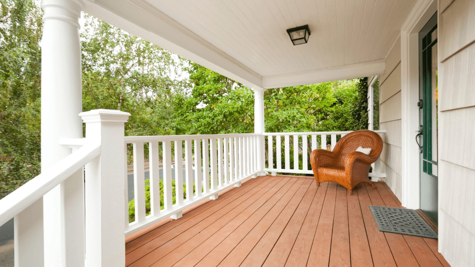 Covered porch with a white railing and composite decking on a New Jersey home