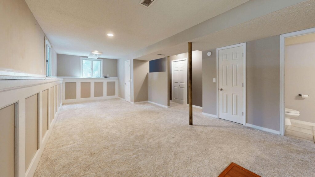 Finished basement with recessed lighting, carpet and a finished stairway