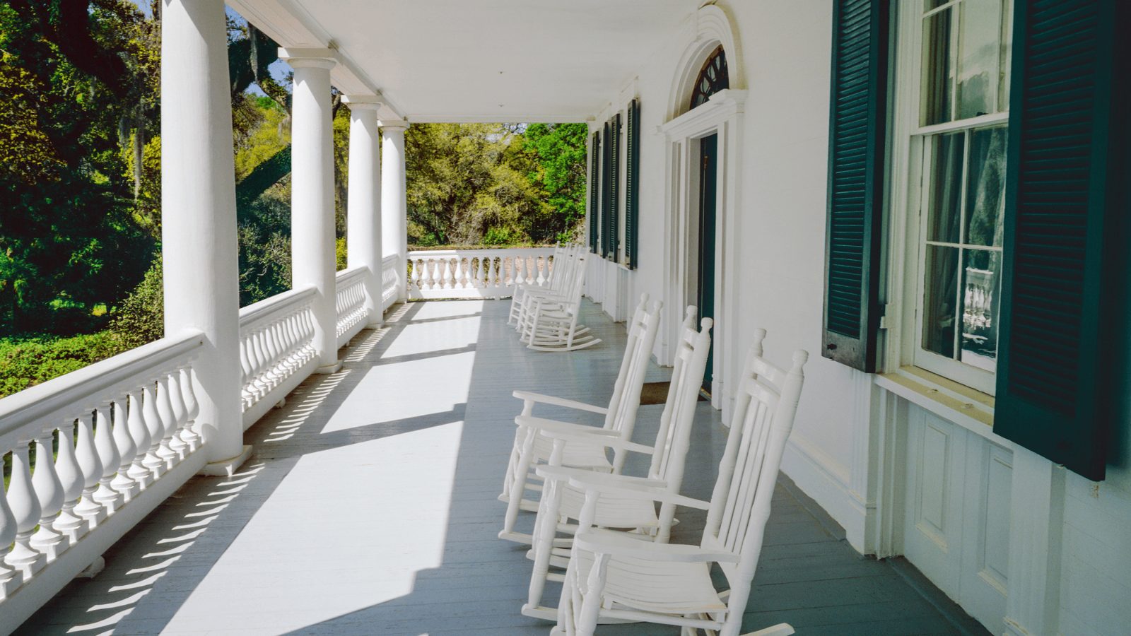 Covered front porch with white rocking chairs and turned balusters on a New Jersey home