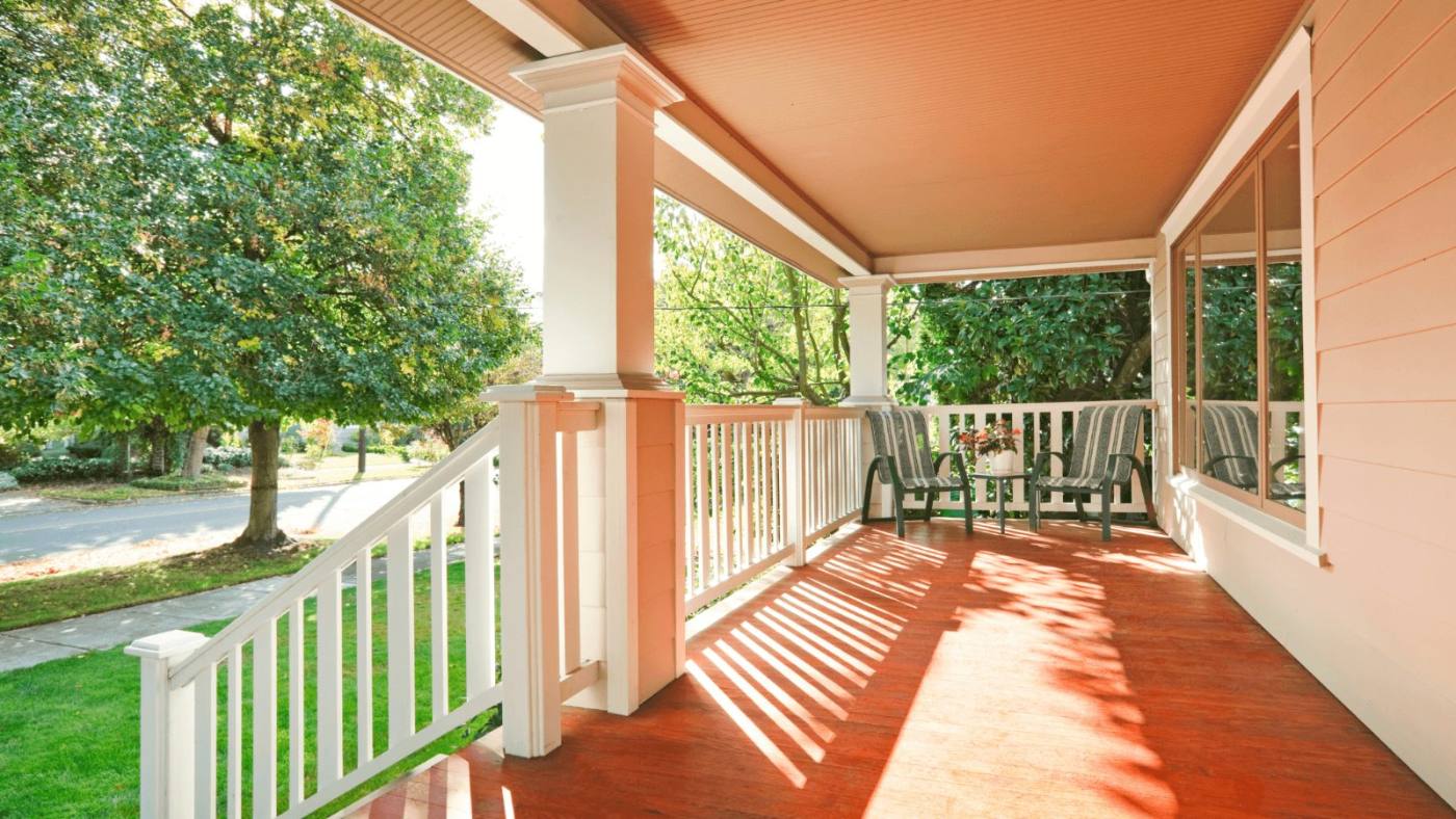 Covered front porch with a tapered column, railing and painted porch floor in New Jersey