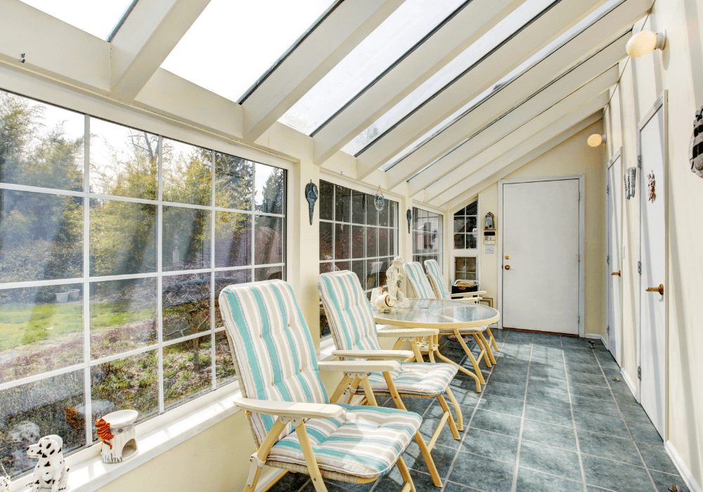 Long sunroom lined with reclining lounge chairs under a glass roof